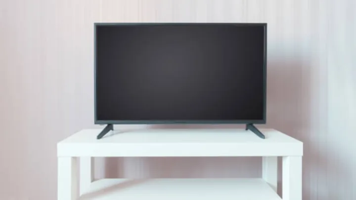 Television supported by attached stand feet on a tabletop